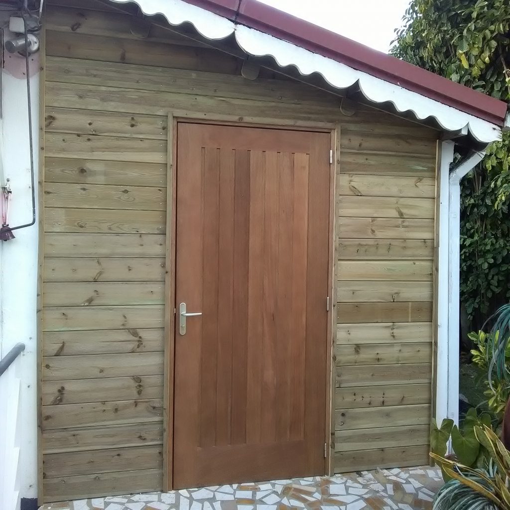 Porte à frises en bois rouge et bardage en pin traité